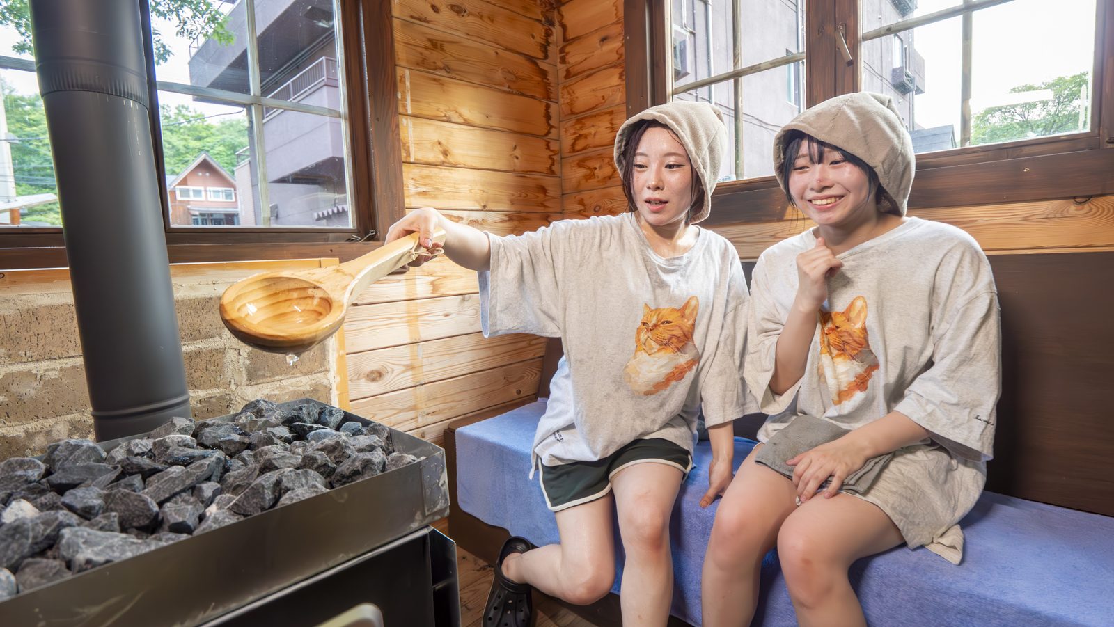 サウナハットをかぶりロウリュを楽しむ二人、小樽・朝里川温泉の貸切サウナ