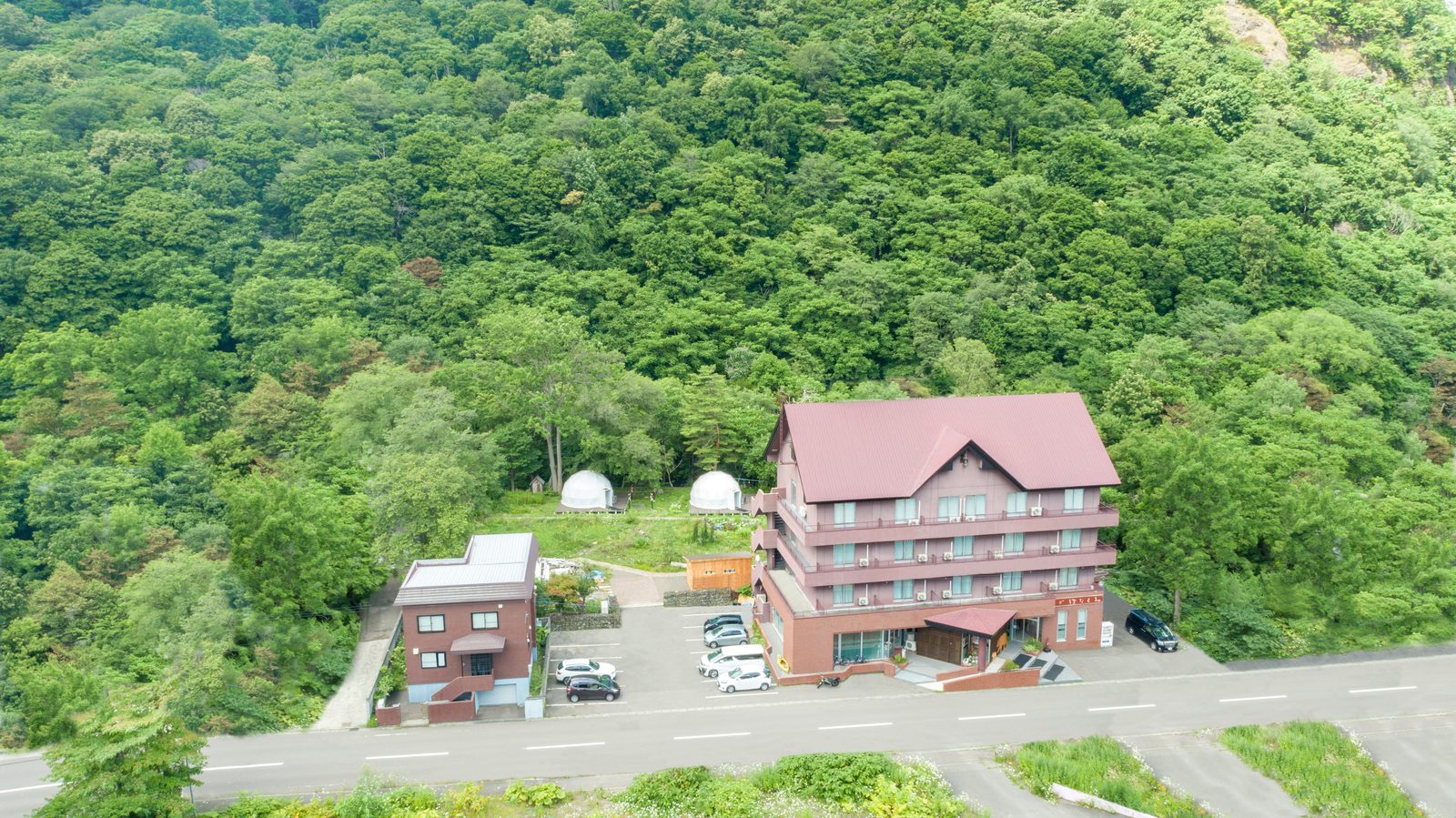 空から見た旅房はなえみ、朝里川温泉の緑に囲まれた立地（札幌から車で約30分）